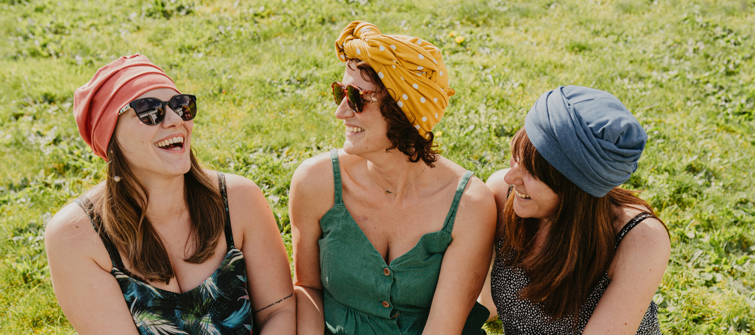 a group of women sitting on grass